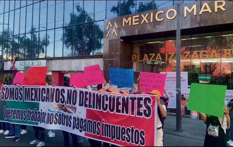 Afuera del edificio clausurado, empleados piden les permitan laborar. EL UNIVERSAL