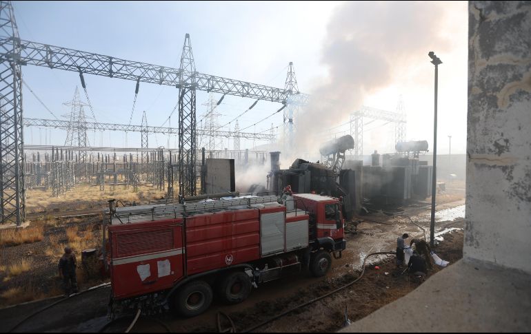 Bomberos extinguen el fuego causado por un misil en una central eléctrica. EFE/Y. Arhab