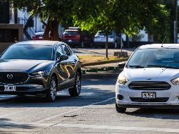 Auto con matrícula a la vista y otro con portaplacas que la oculta parcialmente. La Ley de Movilidad del Estado de Jalisco aclara que no se puede obstaculizar la información contenida en las láminas. EL INFORMADOR/A. Navarro