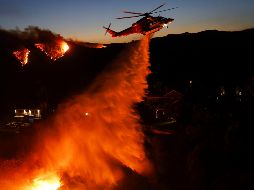 Mansiones en Los Ángeles se encuentran en llamas; helicópteros en el cielo lanzan cargas de agua para combatir el incendio forestal. EFE / EPA / CAROLINE BREHMAN