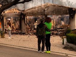 Personas observan una casa afectada por un incendio este miércoles, en Altadena, California.EFE/ A.Varón.