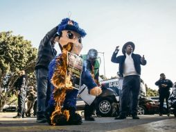 Activistas queman una piñata durante una manifestación, a manera de protesta por los abusos que algunos agentes de seguridad cometen en contra de migrantes. EFE