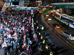 Oficiales de policía separan a los seguidores de Yoon Suk Yeol frente a la casa presidencial de Seúl. EFE / EPA / JEON HEON-KYUN