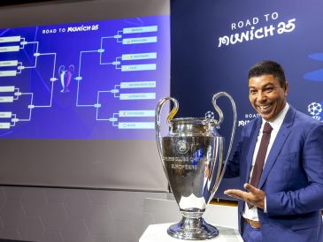 Giovane Elber, exdelantero del Bayern Munich, al lado de la copa de campeones durante el sorteo para los octavos de final. EFE/S. Di Nolfi