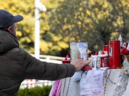 Personas rezan en frente de la estatua de Juan Pablo II, ubicada en la entrada del Hospital Gemelli donde Francisco está hospitalizado. EFE/M. PERCOSSI