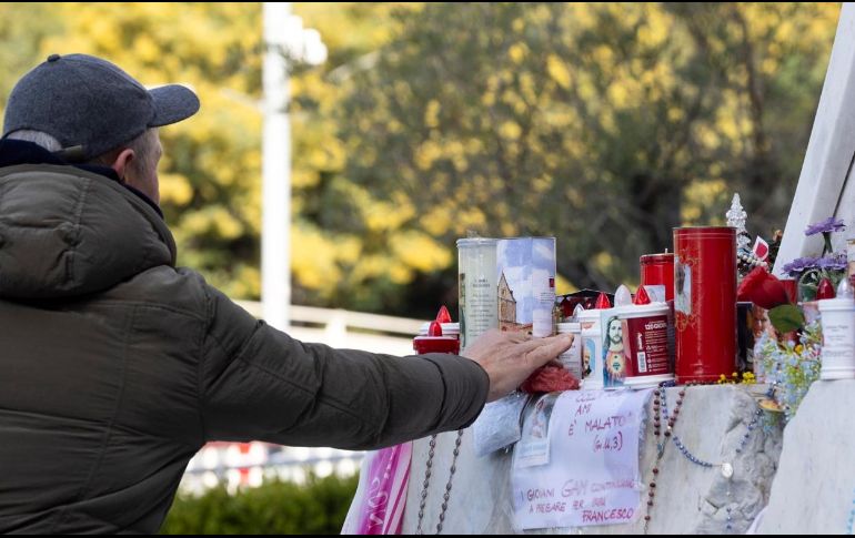 Personas rezan en frente de la estatua de Juan Pablo II, ubicada en la entrada del Hospital Gemelli donde Francisco está hospitalizado. EFE/M. PERCOSSI