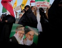 Una mujer iraní sostiene un cartel del ayatolá Jomeini, el fallecido líder revolucionario iraní, a la derecha, y el actual líder supremo, el ayatolá Alí Jamenei. AP / V. Salemi