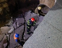 En el incidente, un automóvil compacto y un camión que transportaba arena fueron tragados por el hoyo, mientras que un autobús de pasajeros quedó parcialmente suspendido al borde del colapso. EL INFORMADOR / H. Figueroa