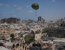 Palestinos en la Ciudad de Gaza corren para recoger ayuda humanitaria lanzada con paracaídas desde el aire. La toma de la capital desplazaría a un millón de personas, muchas de ellas llegadas de otras zonas ya ocupadas. AP/J. Alshrafi