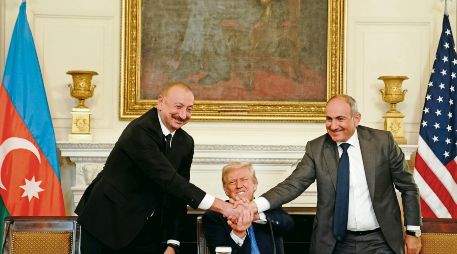 El presidente de Azerbaiyán, Ilham Aliyev, le da la mano al primer ministro armenio Nikol Pashinyan, mientras Donald Trump, mandatario de EU, refuerza el saludo entre ambos. EFE