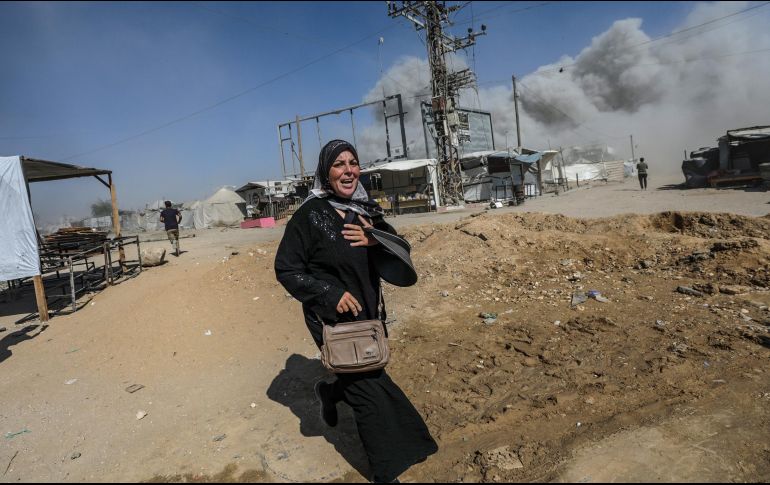 Una mujer palestina corre a refugiarse luego de un ataque aéreo israelí ocurrido el lunes. El mes pasado, Israel aprobó un plan para ocupar la Ciudad de Gaza. EFE/M. Saber