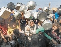 Refugiados palestinos, incluidos niños, esperan alimentos de una cocina de caridad en Khan Yunis, Gaza, durante el alto al fuego entre Israel y Hamás. EFE/H. Imad