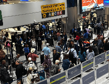 Este viernes, personas hacen fila en el área de seguridad del aeropuerto internacional George Bush, en Houston. EFE / Carlos Ramírez