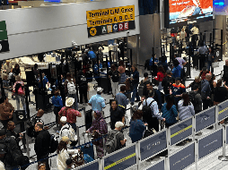 Este viernes, personas hacen fila en el área de seguridad del aeropuerto internacional George Bush, en Houston. EFE / Carlos Ramírez