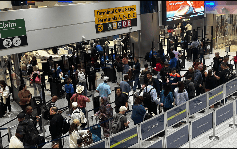 Este viernes, personas hacen fila en el área de seguridad del aeropuerto internacional George Bush, en Houston. EFE / Carlos Ramírez