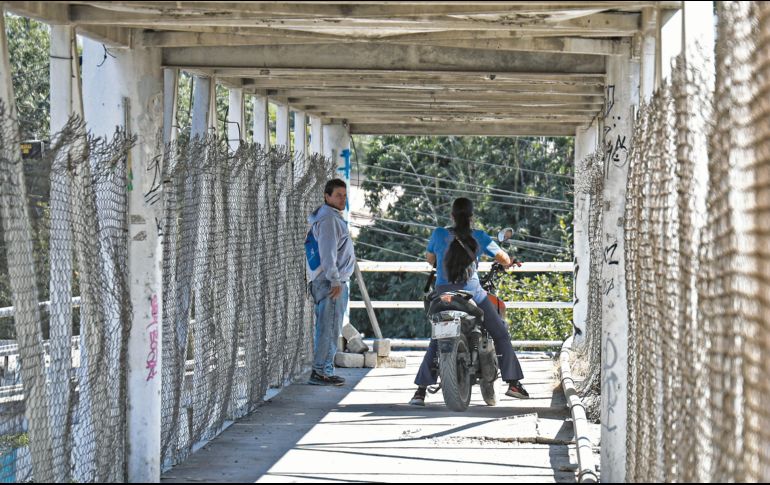 En el puente de la Carretera a Chapala y Guadalupe Montenegro, motociclistas invaden el espacio destinado a los peatones, poniendo en riesgo su seguridad. Mientras tanto, autoridades federales, estatales y municipales se deslindan y se pasan la bolita. Nadie sanciona. EL INFORMADOR/ J. Acosta