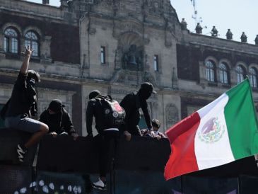 Manifestantes trepan por una valla en inmediaciones del Palacio Nacional en Ciudad de México (CDMX). EFE/J. Méndez
