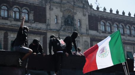 Manifestantes trepan por una valla en inmediaciones del Palacio Nacional en Ciudad de México (CDMX). EFE/J. Méndez