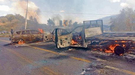 Elementos de seguridad retiran vehículos incendiados tras los bloqueos provocados por presuntos integrantes del cártel en 16 municipios de Michoacán. CORTESÍA
