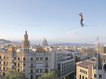 El artista francés Nathan Paulin camina sobre una cuerda en la Plaza de Cataluña, en Barcelona, como parte del Festival Grec, en julio de 2023. AFP/L. Gene