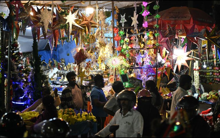 Personas compran luces decorativas en un mercado en vísperas de Navidad cerca de la Basílica de Santa María en Bengaluru, India. AFP