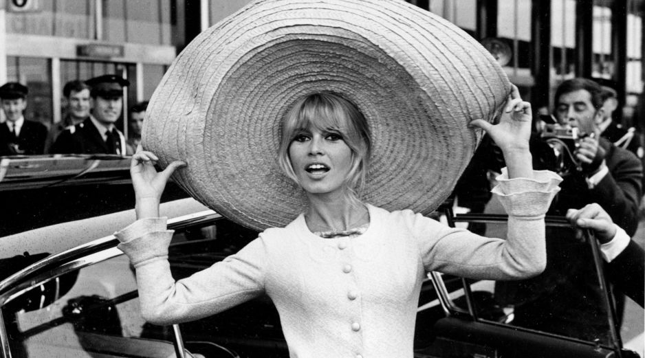Brigitte Bardot posa con un enorme sombrero que trajo de México, a su llegada al aeropuerto de OrlY, el 27 de mayo de 1965, en París, Francia. AP