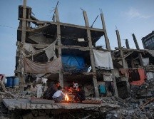 Desplazados palestinos junto a un fuego en los restos de un edificio en Kah Yunis. EFE / EPA / HAITHAM IMAD