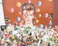 Ofrendas florales se acumularon bajo un mural de David Bowie, pintado por el artista urbano australiano James Cochran (Jimmy C), un día después de anunciarse su muerte, en Brixton, al sur de Londres. AFP