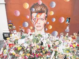 Ofrendas florales se acumularon bajo un mural de David Bowie, pintado por el artista urbano australiano James Cochran (Jimmy C), un día después de anunciarse su muerte, en Brixton, al sur de Londres. AFP