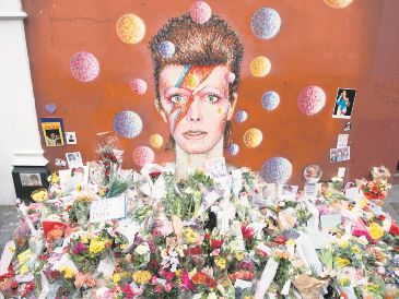 Ofrendas florales se acumularon bajo un mural de David Bowie, pintado por el artista urbano australiano James Cochran (Jimmy C), un día después de anunciarse su muerte, en Brixton, al sur de Londres. AFP