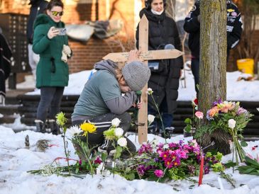 Una mujer ora en un monumento improvisado en el lugar en el que una mujer fue asesinada a tiros por un agente de Inmigración y Control de Aduanas (ICE) en Minneapolis, Minnesota. EFE / EPA / CRAIG LASSIG
