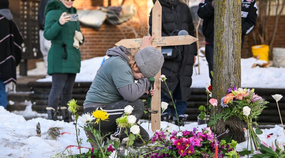 Una mujer ora en un monumento improvisado en el lugar en el que una mujer fue asesinada a tiros por un agente de Inmigración y Control de Aduanas (ICE) en Minneapolis, Minnesota. EFE / EPA / CRAIG LASSIG