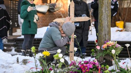 Una mujer ora en un monumento improvisado en el lugar en el que una mujer fue asesinada a tiros por un agente de Inmigración y Control de Aduanas (ICE) en Minneapolis, Minnesota. EFE / EPA / CRAIG LASSIG