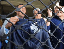 Personas muestran la chaqueta que usaba la diputada del Partido Nacional Gladys Aurora López, luego de ser afectada por un artefacto explosivo. EFE / G. AMADOR