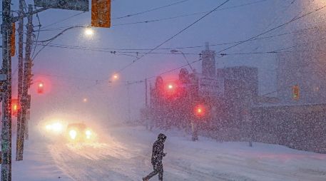 Personas caminan por el centro de Toronto, mientras una tormenta invernal atraviesa la región. AP