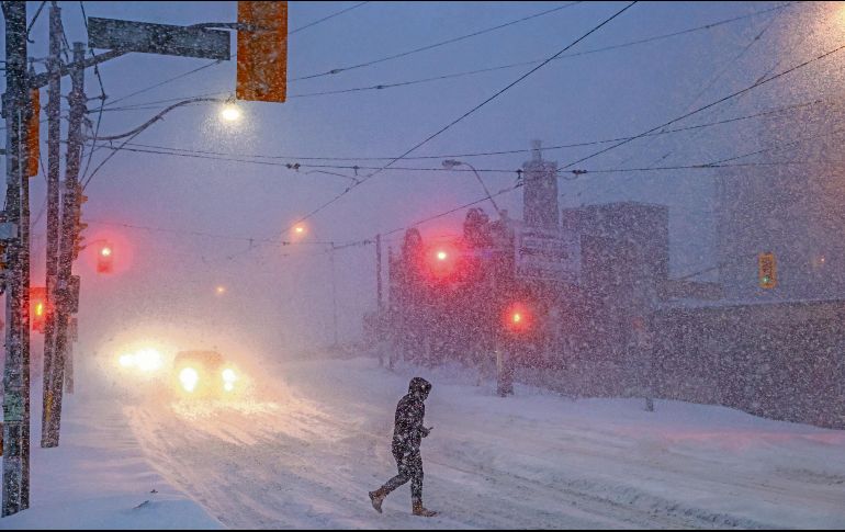 Personas caminan por el centro de Toronto, mientras una tormenta invernal atraviesa la región. AP