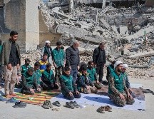 Un grupo de voluntarios basijis -milicia islámica- reza este miércoles, al lado de un edificio destruido en los bombardeos israelíes-estadounidenses contra Irán en la calle en la calle Kargar, cerca de la plaza Engelab en Teherán. EFE/ J. León