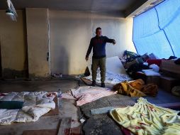 Un hombre libanés desplazado que huyó con su familia del suburbio del sur para refugiarse en un garaje abandonado muestra el lugar donde sus hijos resultaron heridos por las esquirlas de un cohete que impactó en un hotel cercano en un ataque israelí en el distrito de Raouche en Beirut, Líbano, este domingo 8 de marzo de 2026. EFE/W. HAMZEH