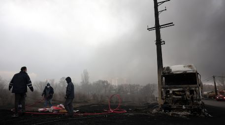 Los iraníes trabajan mientras aún sale humo de la refinería de petróleo de Shahran tras el ataque aéreo de anoche en Teherán, Irán, 8 de marzo de 2026.  EFE/A. TAHERKENAREH