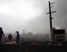 Los iraníes trabajan mientras aún sale humo de la refinería de petróleo de Shahran tras el ataque aéreo de anoche en Teherán, Irán, 8 de marzo de 2026.  EFE/A. TAHERKENAREH