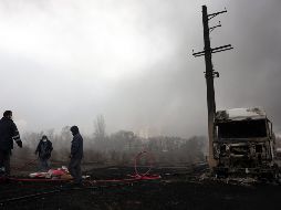 Los iraníes trabajan mientras aún sale humo de la refinería de petróleo de Shahran tras el ataque aéreo de anoche en Teherán, Irán, 8 de marzo de 2026.  EFE/A. TAHERKENAREH