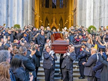 Músicos, principalmente trombonistas, tocan música mientras el cuerpo de Willie Colón sale de la iglesia de San Patricio en Nueva York. EFE