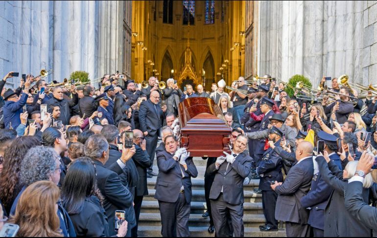Músicos, principalmente trombonistas, tocan música mientras el cuerpo de Willie Colón sale de la iglesia de San Patricio en Nueva York. EFE