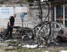 Un policía israelí inspecciona coches calcinados tras el impacto de fragmentos de un misil balístico iraní interceptado en Tel Aviv, Israel, el 15 de marzo de 2026. EFE/A. SULTAN