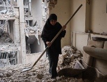 Una mujer trata de limpiar una vivienda en el barrio de Haft Chenar de Teherán que resultó dañada en un ataque de Estados Unidos e Israel. EFE/J. León