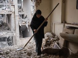 Una mujer trata de limpiar una vivienda en el barrio de Haft Chenar de Teherán que resultó dañada en un ataque de Estados Unidos e Israel. EFE/J. León