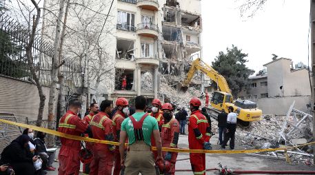 Bomberos y funcionarios iraníes trabajan en el lugar donde se encuentran los edificios residenciales dañados en el norte de Teherán, Irán, el 23 de marzo de 2026. EFE/A. TAHERKENAREH