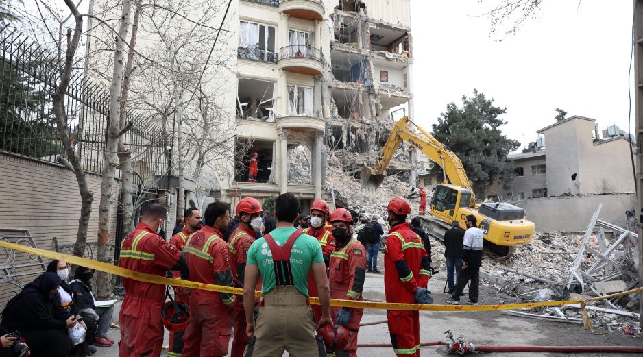 Bomberos y funcionarios iraníes trabajan en el lugar donde se encuentran los edificios residenciales dañados en el norte de Teherán, Irán, el 23 de marzo de 2026. EFE/A. TAHERKENAREH