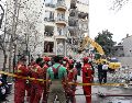 Bomberos y funcionarios iraníes trabajan en el lugar donde se encuentran los edificios residenciales dañados en el norte de Teherán, Irán, el 23 de marzo de 2026. EFE/A. TAHERKENAREH