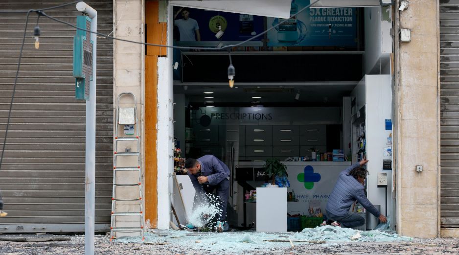 Trabajadores limpian los cristales rotos de una farmacia tras un ataque israelí en la zona de Al Chiyah, un suburbio al sur de Beirut, Líbano. EFE/W. Hamzeh